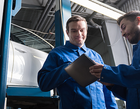 Mechanics both checking an inspection sheet - MOT Slough